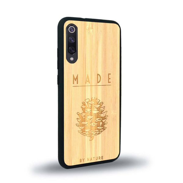 Coque de protection en bois véritable fabriquée en France pour Xiaomi Mi Note 10 Lite sur le thème de la nature et des arbres avec une gravure représentant une pomme de pin et la phrase "made by nature"