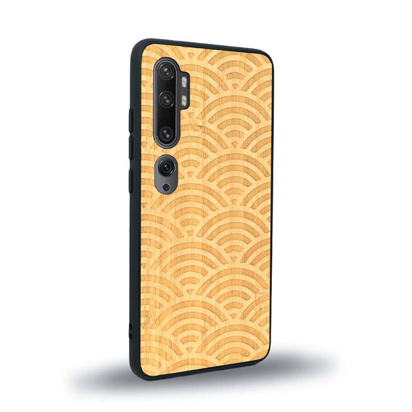 Coque de protection en bois véritable fabriquée en France pour Xiaomi Mi Note 10 Pro baptisée "La Sinjak" avec un motif de gravure abstrait représentant la répétition d'un symbole wifi