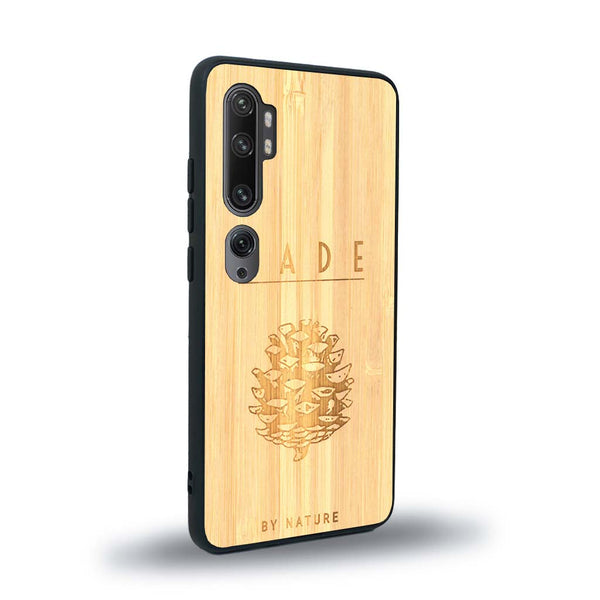 Coque de protection en bois véritable fabriquée en France pour Xiaomi Mi Note 10 Pro sur le thème de la nature et des arbres avec une gravure représentant une pomme de pin et la phrase "made by nature"
