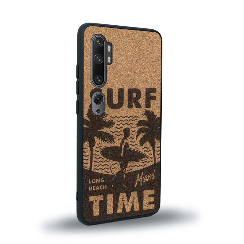 Coque de protection en bois véritable fabriquée en France pour Xiaomi Mi Note 10 Pro sur le thème chill avec un motif représentant une silouhette tenant une planche de surf sur une plage entouré de palmiers et les mots "Surf Time Long Beach Miami"