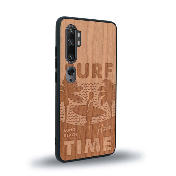 Coque de protection en bois véritable fabriquée en France pour Xiaomi Mi Note 10 Pro sur le thème chill avec un motif représentant une silouhette tenant une planche de surf sur une plage entouré de palmiers et les mots "Surf Time Long Beach Miami"
