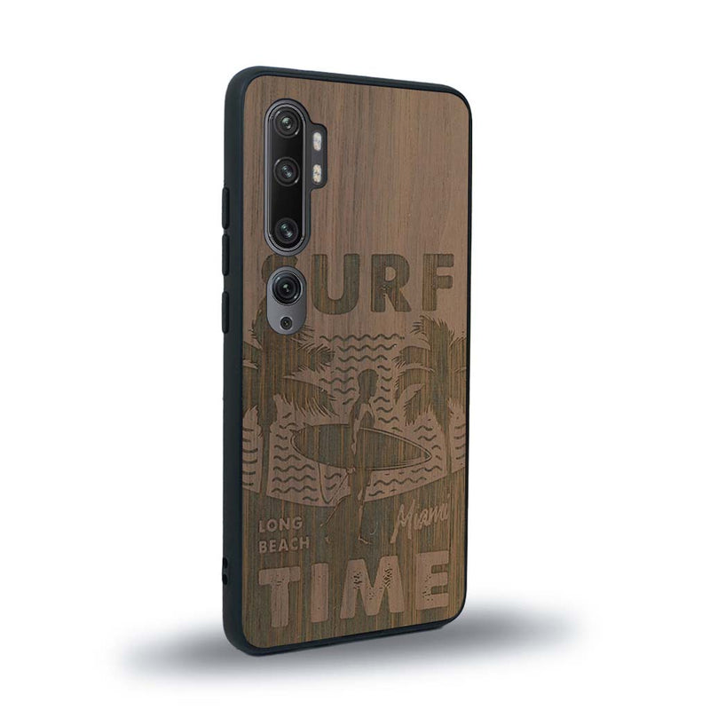 Coque de protection en bois véritable fabriquée en France pour Xiaomi Mi Note 10 Pro sur le thème chill avec un motif représentant une silouhette tenant une planche de surf sur une plage entouré de palmiers et les mots "Surf Time Long Beach Miami"