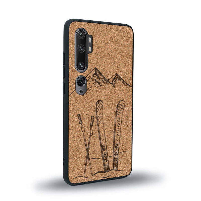 Coque de protection en bois véritable fabriquée en France pour Xiaomi Mi Note 10 Pro sur le thème de la montagne, du ski et de la neige avec un motif représentant une paire de ski plantée dans la neige avec en fond des montagnes enneigées