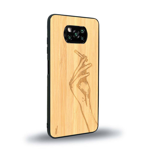 Coque de protection en bois véritable fabriquée en France pour Xiaomi Poco X3 Nfc représentant une main de femme tenant une cigarette de type line art en collaboration avec l'artiste Maud Dabs