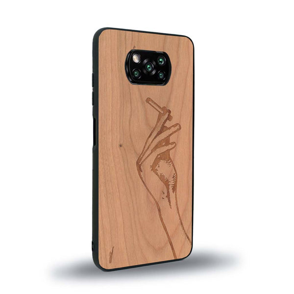 Coque de protection en bois véritable fabriquée en France pour Xiaomi Poco X3 Nfc représentant une main de femme tenant une cigarette de type line art en collaboration avec l'artiste Maud Dabs