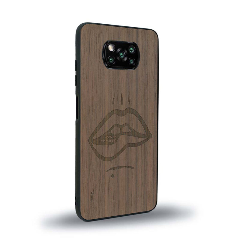 Coque de protection en bois véritable fabriquée en France pour Xiaomi Poco X3 Nfc représentant de manière minimaliste une bouche de féminine se mordant le coin de la lèvre de manière sensuelle dessinée à la main par l'artiste Maud Dabs