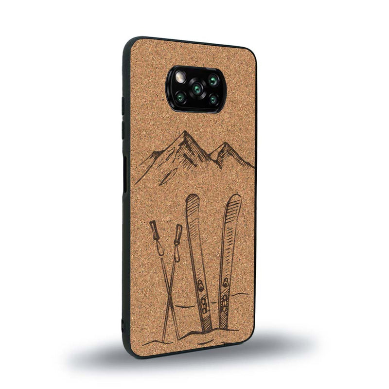 Coque de protection en bois véritable fabriquée en France pour Xiaomi Poco X3 Nfc sur le thème de la montagne, du ski et de la neige avec un motif représentant une paire de ski plantée dans la neige avec en fond des montagnes enneigées