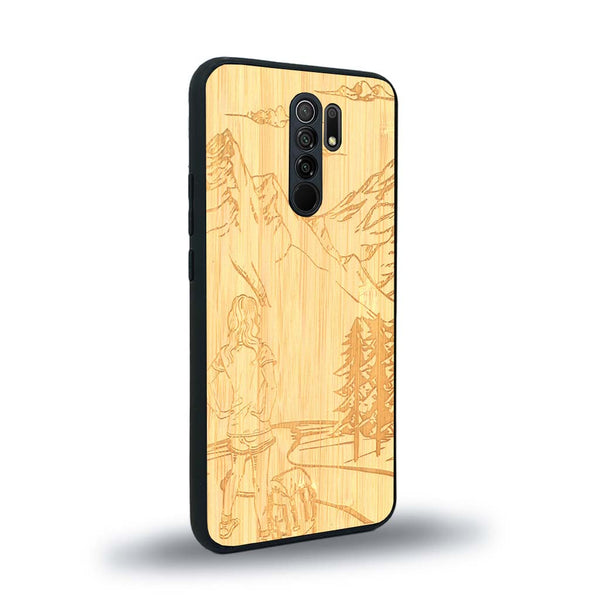 Coque de protection en bois véritable fabriquée en France pour Xiaomi Redmi 9 sur le thème de la randonnée en montagne et de l'aventure avec une gravure représentant une femme de dos face à un paysage de nature
