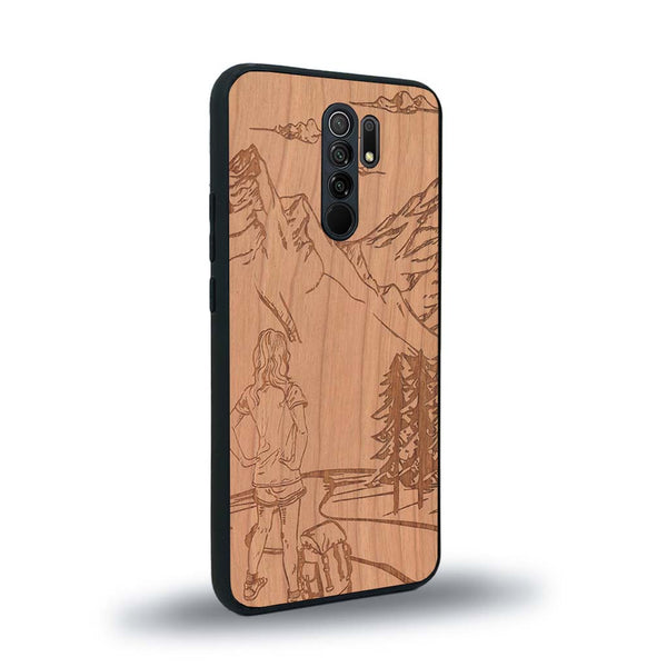 Coque de protection en bois véritable fabriquée en France pour Xiaomi Redmi 9 sur le thème de la randonnée en montagne et de l'aventure avec une gravure représentant une femme de dos face à un paysage de nature