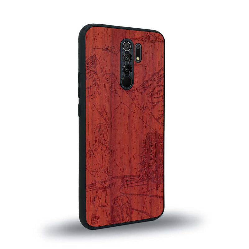 Coque de protection en bois véritable fabriquée en France pour Xiaomi Redmi 9 sur le thème de la randonnée en montagne et de l'aventure avec une gravure représentant une femme de dos face à un paysage de nature