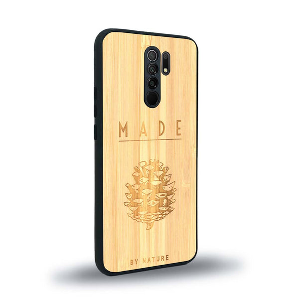 Coque de protection en bois véritable fabriquée en France pour Xiaomi Redmi 9 sur le thème de la nature et des arbres avec une gravure représentant une pomme de pin et la phrase "made by nature"