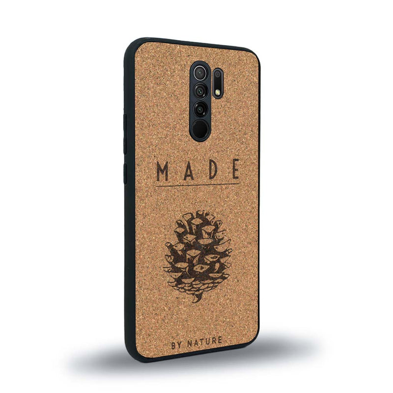 Coque de protection en bois véritable fabriquée en France pour Xiaomi Redmi 9 sur le thème de la nature et des arbres avec une gravure représentant une pomme de pin et la phrase "made by nature"