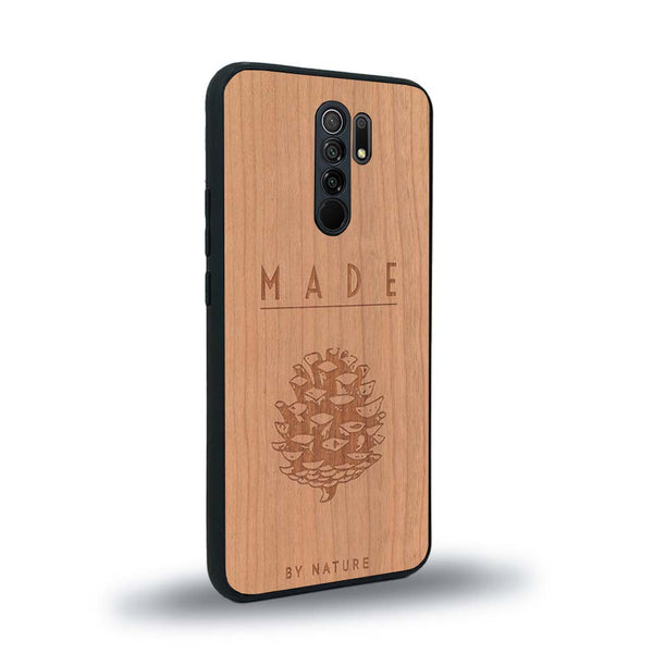 Coque de protection en bois véritable fabriquée en France pour Xiaomi Redmi 9 sur le thème de la nature et des arbres avec une gravure représentant une pomme de pin et la phrase "made by nature"