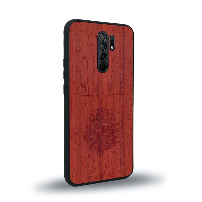 Coque de protection en bois véritable fabriquée en France pour Xiaomi Redmi 9 sur le thème de la nature et des arbres avec une gravure représentant une pomme de pin et la phrase "made by nature"
