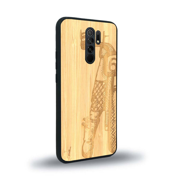 Coque de protection en bois véritable fabriquée en France pour Xiaomi Redmi 9 représentant une vue de face d'une femme sur une moto vintage dessinée à la main par l'artiste Maud Dabs