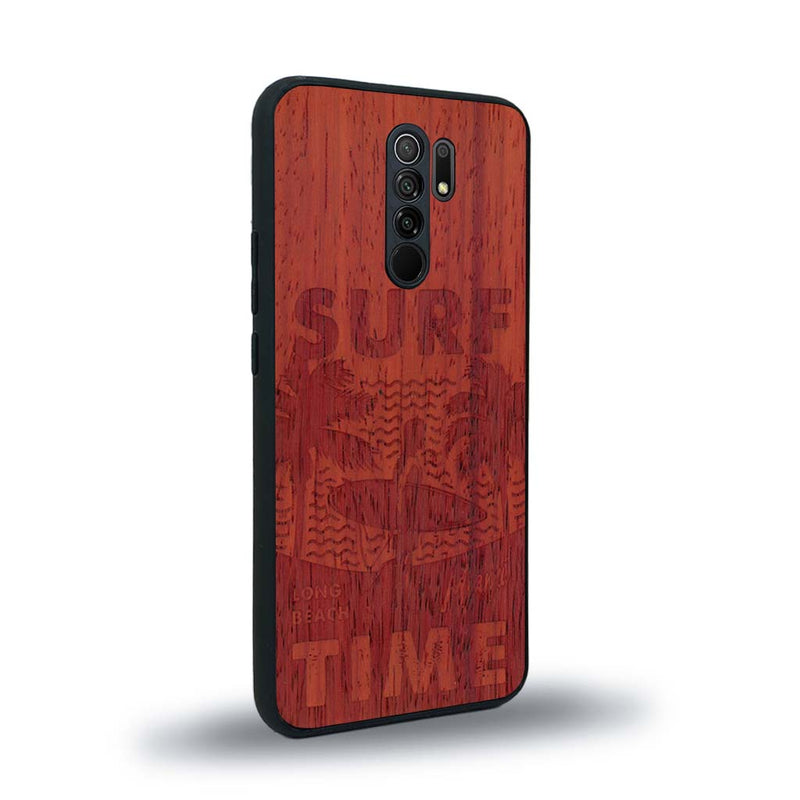 Coque de protection en bois véritable fabriquée en France pour Xiaomi Redmi 9 sur le thème chill avec un motif représentant une silouhette tenant une planche de surf sur une plage entouré de palmiers et les mots "Surf Time Long Beach Miami"