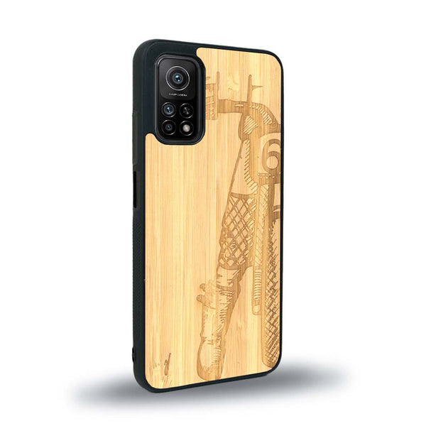 Coque de protection en bois véritable fabriquée en France pour Xiaomi Redmi 9T représentant une vue de face d'une femme sur une moto vintage dessinée à la main par l'artiste Maud Dabs