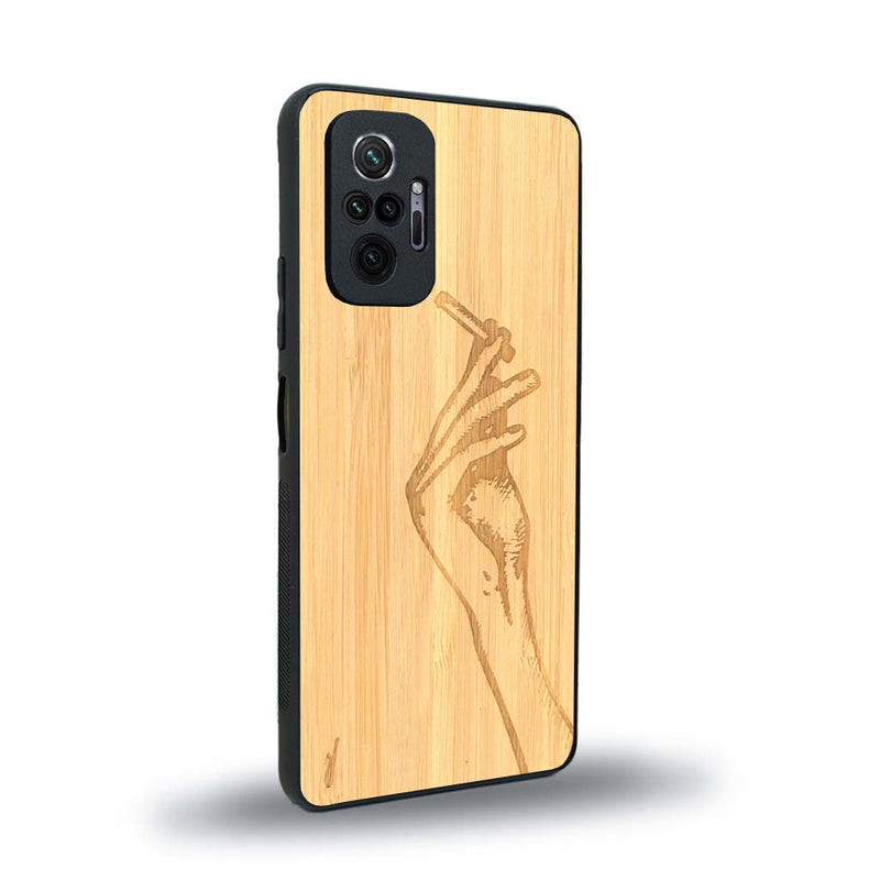 Coque de protection en bois véritable fabriquée en France pour Xiaomi Redmi Note 10 Pro représentant une main de femme tenant une cigarette de type line art en collaboration avec l'artiste Maud Dabs