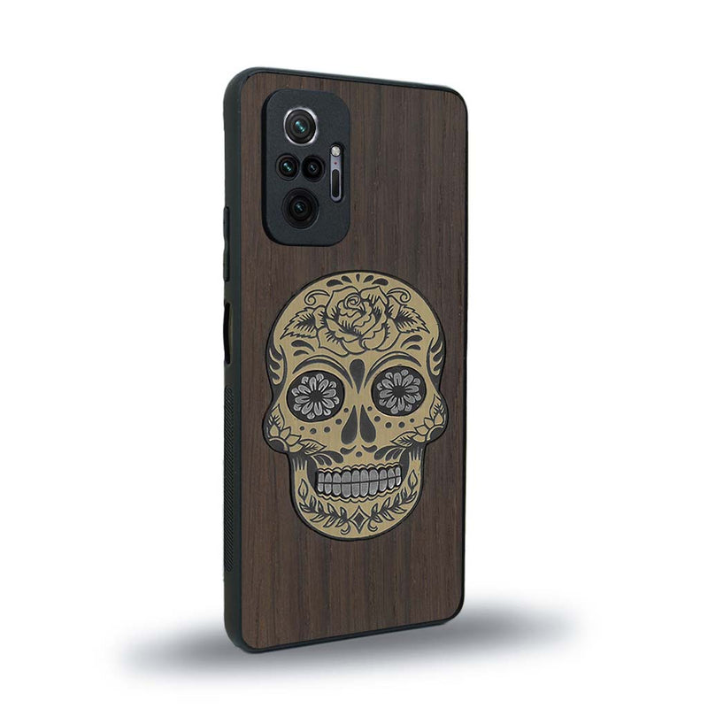 Coque de protection en bois véritable fabriquée en France pour Xiaomi Redmi Note 10 Pro alliant du chêne fumé avec du métal argenté et doré représentant une tête de mort mexicaine sur le thème Dia de los Muertos