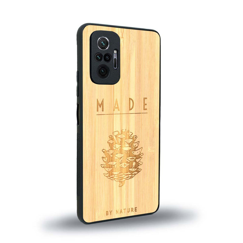 Coque de protection en bois véritable fabriquée en France pour Xiaomi Redmi Note 10 Pro sur le thème de la nature et des arbres avec une gravure représentant une pomme de pin et la phrase "made by nature"