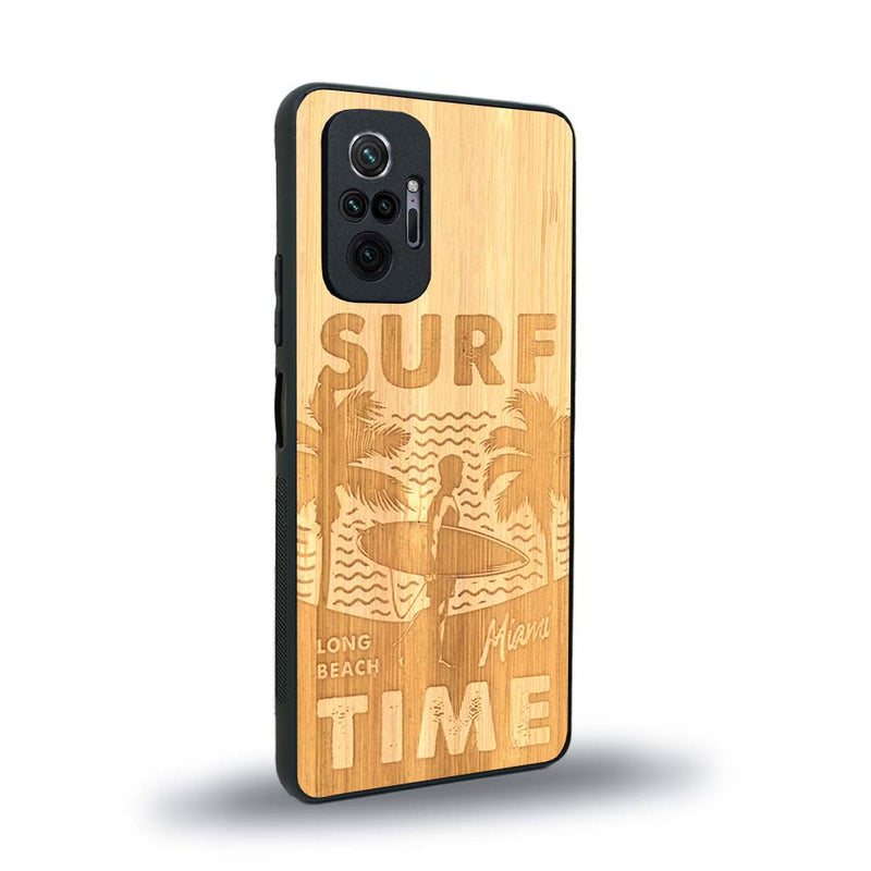 Coque de protection en bois véritable fabriquée en France pour Xiaomi Redmi Note 10 Pro sur le thème chill avec un motif représentant une silouhette tenant une planche de surf sur une plage entouré de palmiers et les mots "Surf Time Long Beach Miami"