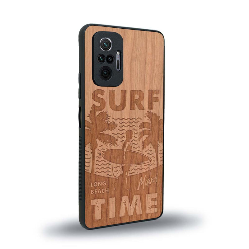Coque de protection en bois véritable fabriquée en France pour Xiaomi Redmi Note 10 Pro sur le thème chill avec un motif représentant une silouhette tenant une planche de surf sur une plage entouré de palmiers et les mots "Surf Time Long Beach Miami"