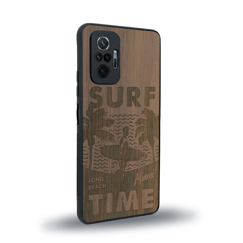 Coque de protection en bois véritable fabriquée en France pour Xiaomi Redmi Note 10 Pro sur le thème chill avec un motif représentant une silouhette tenant une planche de surf sur une plage entouré de palmiers et les mots "Surf Time Long Beach Miami"