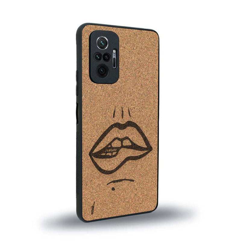 Coque de protection en bois véritable fabriquée en France pour Xiaomi Redmi Note 10 Pro représentant de manière minimaliste une bouche de féminine se mordant le coin de la lèvre de manière sensuelle dessinée à la main par l'artiste Maud Dabs