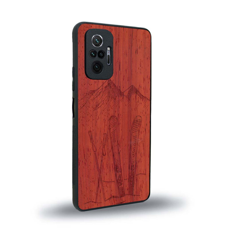 Coque de protection en bois véritable fabriquée en France pour Xiaomi Redmi Note 10 Pro sur le thème de la montagne, du ski et de la neige avec un motif représentant une paire de ski plantée dans la neige avec en fond des montagnes enneigées