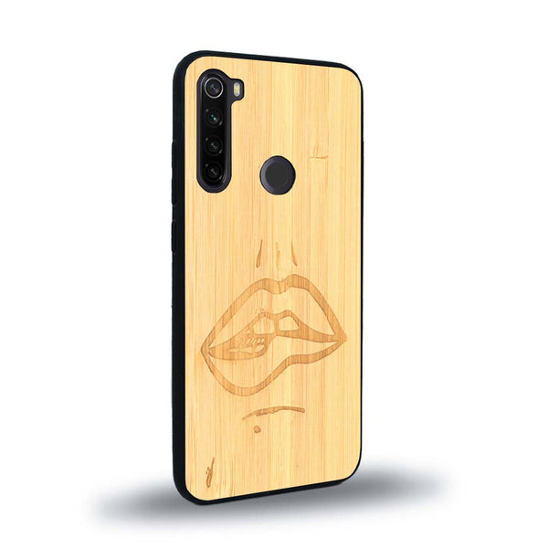 Coque de protection en bois véritable fabriquée en France pour Xiaomi Redmi Note 8 représentant de manière minimaliste une bouche de féminine se mordant le coin de la lèvre de manière sensuelle dessinée à la main par l'artiste Maud Dabs