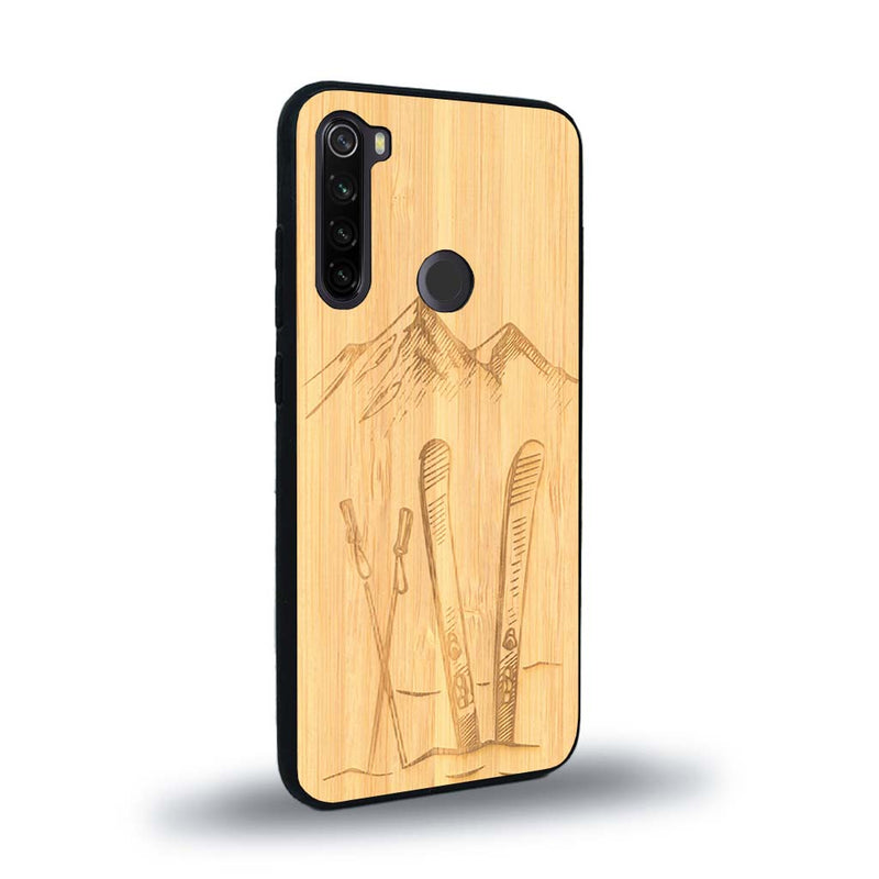 Coque de protection en bois véritable fabriquée en France pour Xiaomi Redmi Note 8T sur le thème de la montagne, du ski et de la neige avec un motif représentant une paire de ski plantée dans la neige avec en fond des montagnes enneigées