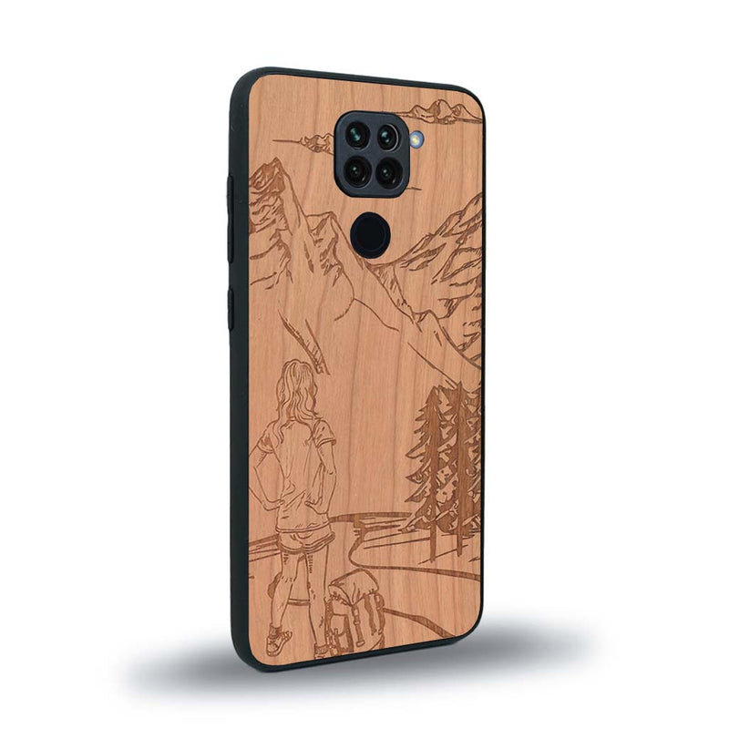 Coque de protection en bois véritable fabriquée en France pour Xiaomi Redmi Note 9 sur le thème de la randonnée en montagne et de l'aventure avec une gravure représentant une femme de dos face à un paysage de nature