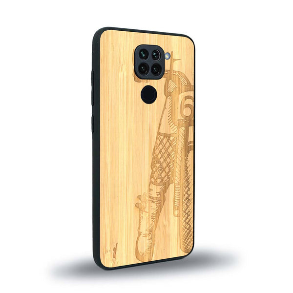 Coque de protection en bois véritable fabriquée en France pour Xiaomi Redmi Note 9 représentant une vue de face d'une femme sur une moto vintage dessinée à la main par l'artiste Maud Dabs