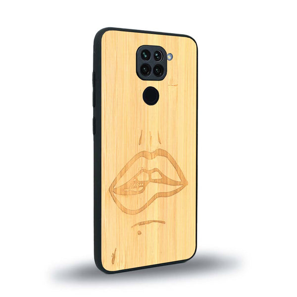 Coque de protection en bois véritable fabriquée en France pour Xiaomi Redmi Note 9 représentant de manière minimaliste une bouche de féminine se mordant le coin de la lèvre de manière sensuelle dessinée à la main par l'artiste Maud Dabs